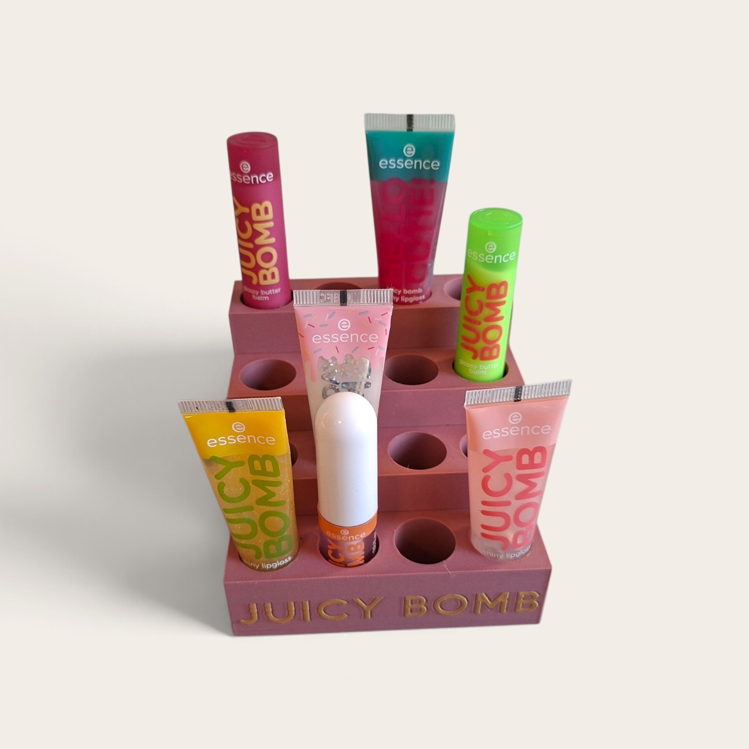 Mat poederroze Juicy Bomb houder met gouden letters. Er kunnen allemaal soorten make-up in deze standaard: lipgloss, lippenstift, mascara, oogpotlood, camouflagestick, etc.